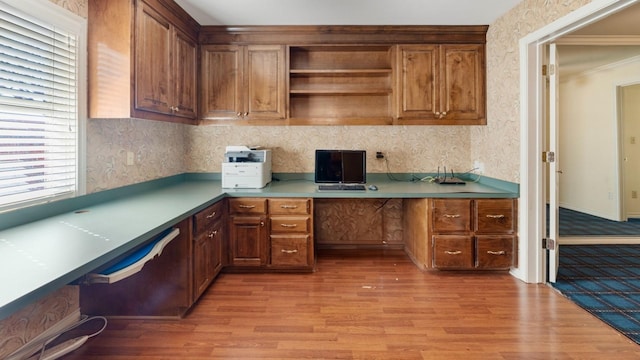 home office featuring built in desk and light hardwood / wood-style flooring