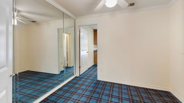 carpeted spare room featuring ornamental molding and ceiling fan