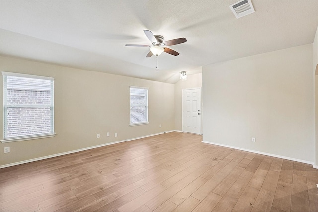 empty room with hardwood / wood-style flooring, lofted ceiling, and ceiling fan