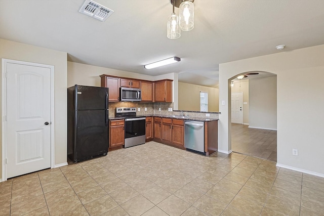 kitchen featuring decorative backsplash, light tile patterned flooring, stainless steel appliances, and stone countertops