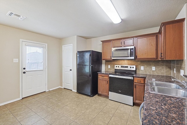 kitchen with sink, backsplash, stainless steel appliances, and light tile patterned floors