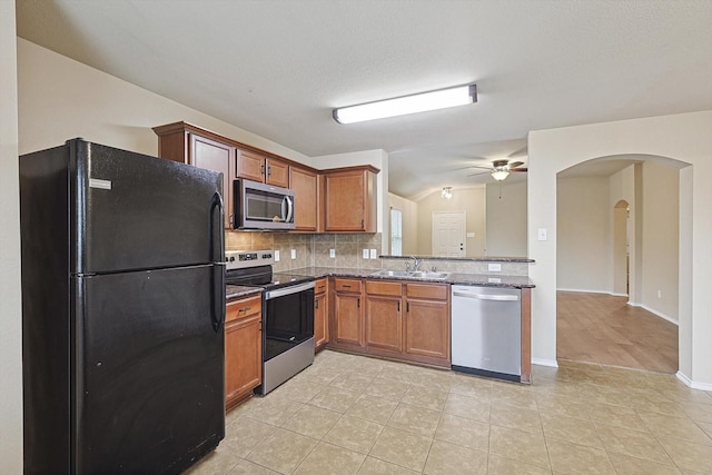 kitchen featuring sink, light tile patterned floors, ceiling fan, appliances with stainless steel finishes, and decorative backsplash