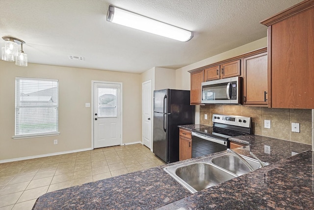 kitchen with stainless steel appliances, sink, decorative backsplash, and light tile patterned floors