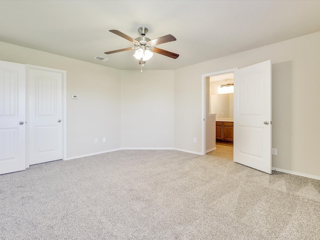 unfurnished bedroom featuring connected bathroom, light carpet, and ceiling fan