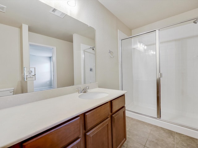 bathroom with tile patterned flooring, walk in shower, vanity, and toilet