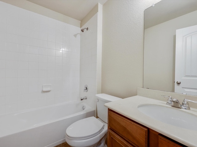 full bathroom featuring vanity, tiled shower / bath, and toilet