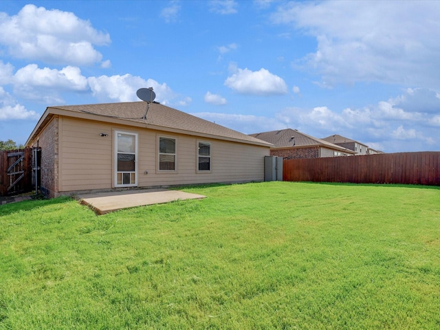 rear view of property featuring a yard and a patio