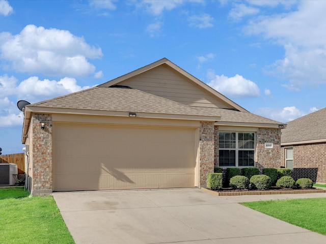 ranch-style home featuring central AC unit and a garage