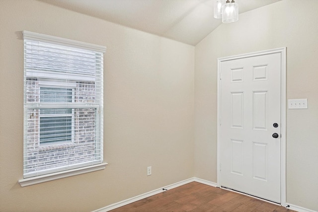 spare room with vaulted ceiling, plenty of natural light, and hardwood / wood-style floors