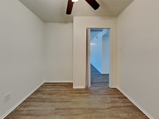 empty room with ceiling fan, light hardwood / wood-style flooring, and a textured ceiling