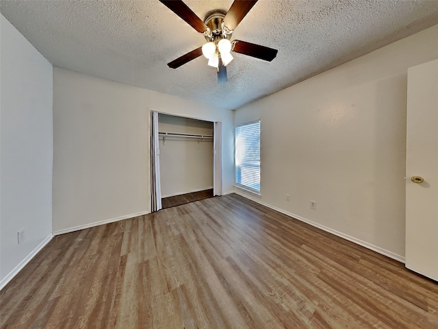 unfurnished bedroom featuring ceiling fan, light hardwood / wood-style flooring, a closet, and a textured ceiling