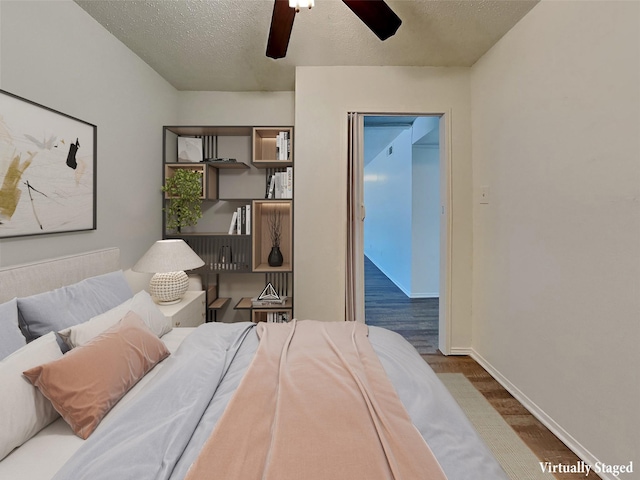 bedroom with a textured ceiling and dark hardwood / wood-style floors