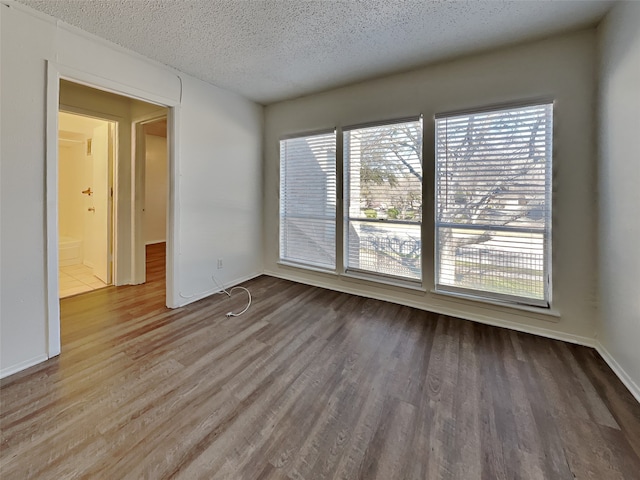 unfurnished room with hardwood / wood-style flooring and a textured ceiling