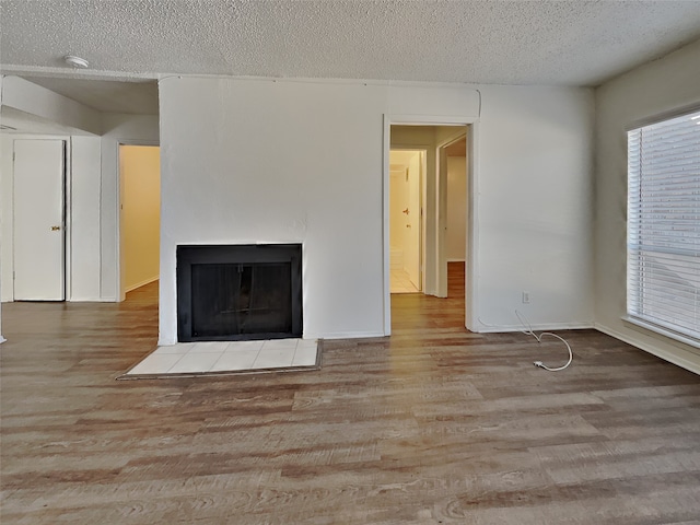 unfurnished living room featuring light hardwood / wood-style floors and a textured ceiling