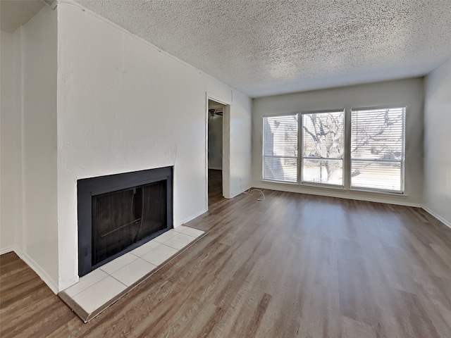 unfurnished living room featuring light hardwood / wood-style floors and a textured ceiling