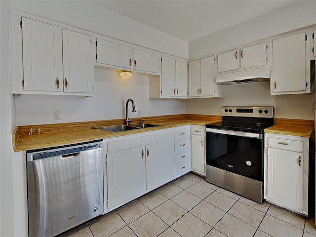 kitchen with sink, stainless steel appliances, white cabinets, and light tile patterned flooring