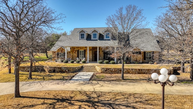 cape cod-style house with covered porch