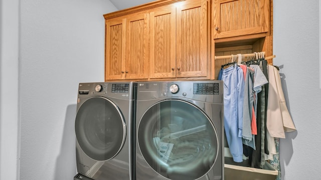 laundry room with cabinets and washing machine and clothes dryer