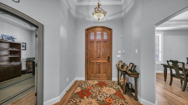 entrance foyer with hardwood / wood-style flooring and ornamental molding