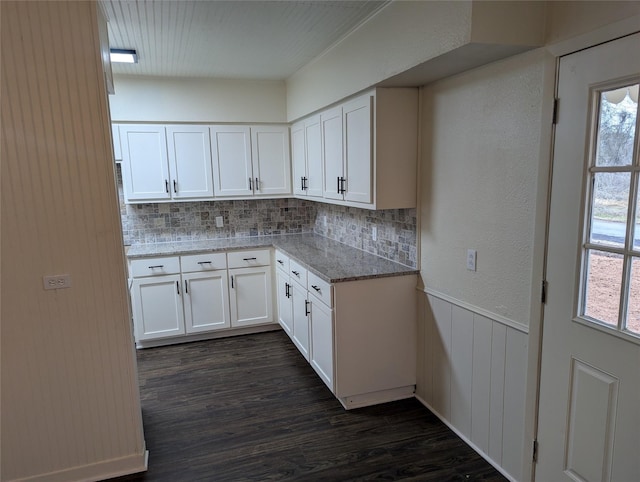 kitchen featuring white cabinetry, a healthy amount of sunlight, dark hardwood / wood-style flooring, and light stone countertops