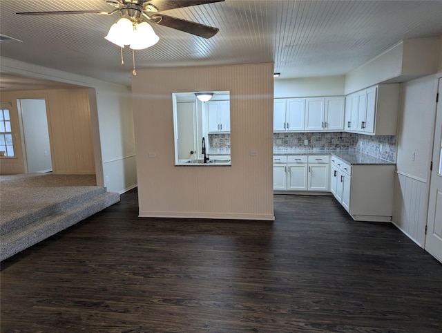 kitchen with ceiling fan, backsplash, dark hardwood / wood-style floors, light stone counters, and white cabinets