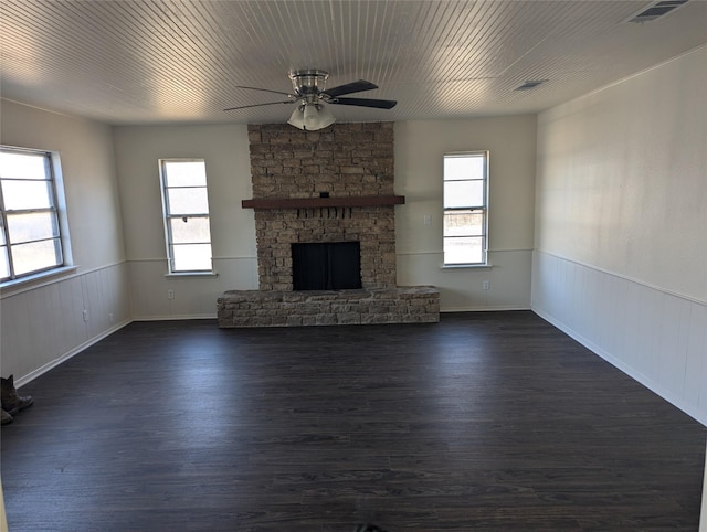 unfurnished living room with wood ceiling, ceiling fan, dark hardwood / wood-style floors, and a stone fireplace