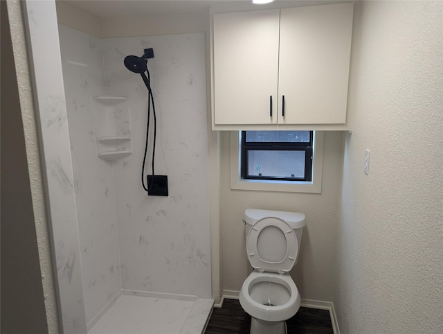 bathroom featuring a shower, hardwood / wood-style floors, and toilet