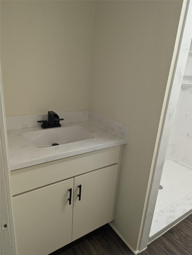 bathroom with hardwood / wood-style flooring, vanity, and walk in shower