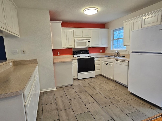 kitchen featuring white cabinetry, sink, a textured ceiling, and white appliances