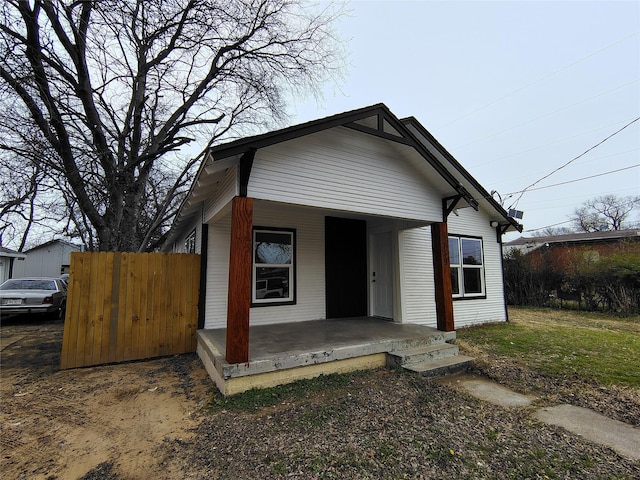 view of front facade featuring a porch and fence