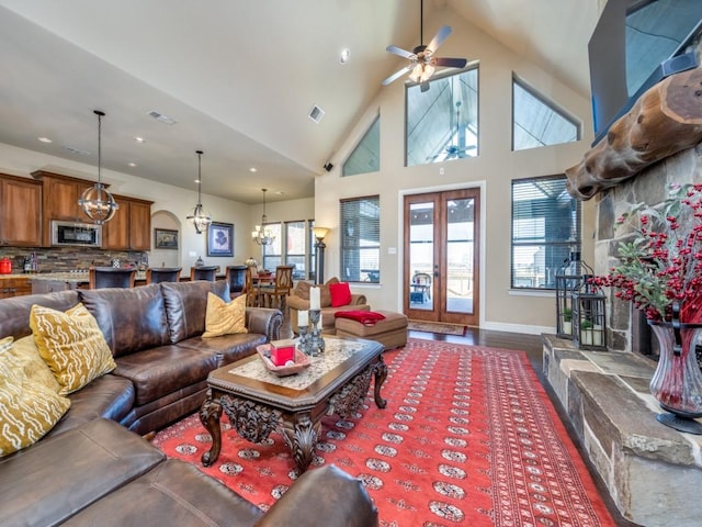 living room with dark hardwood / wood-style floors, a wealth of natural light, high vaulted ceiling, and french doors