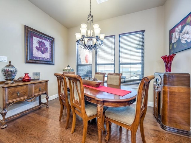 dining area with hardwood / wood-style floors and a notable chandelier