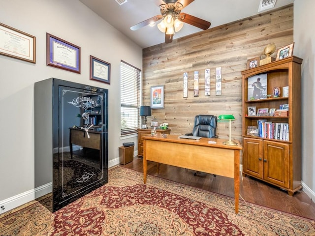 office featuring ceiling fan, wood-type flooring, and wooden walls