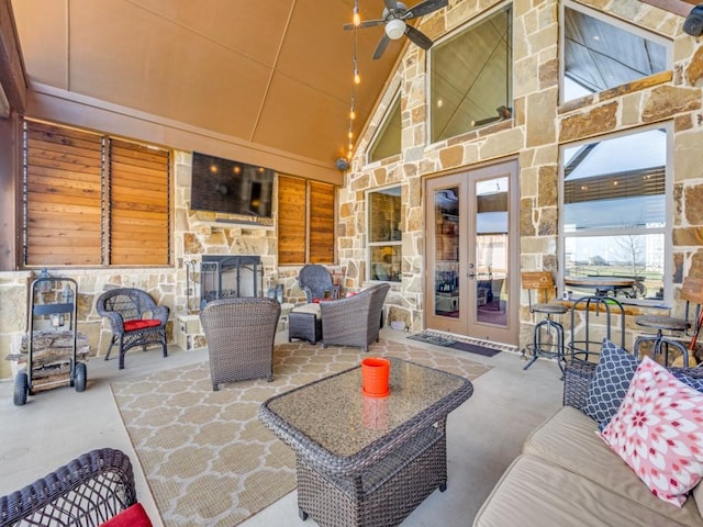 view of patio / terrace with french doors, ceiling fan, and an outdoor living space with a fireplace