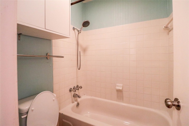 bathroom with tiled shower / bath combo and toilet