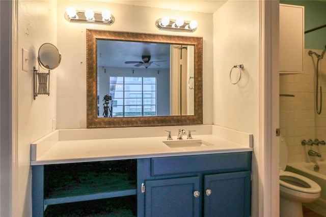 full bathroom featuring vanity, ceiling fan, tiled shower / bath combo, and toilet