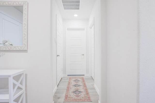 hallway with light hardwood / wood-style floors