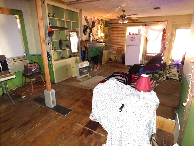 living room featuring heating unit, wood-type flooring, and ceiling fan