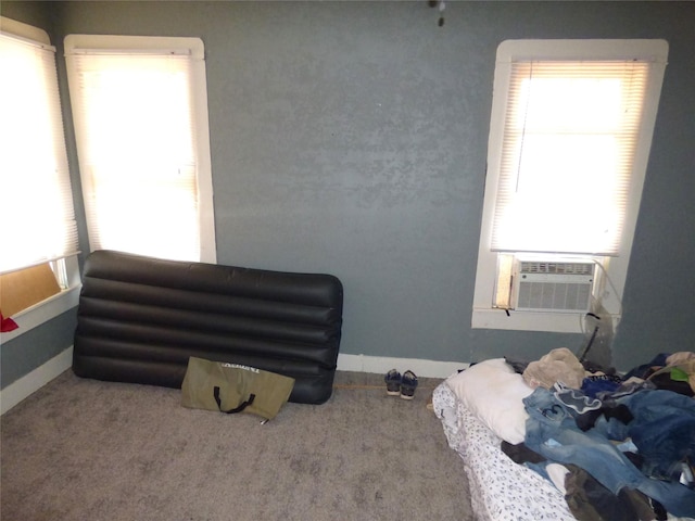 bedroom featuring multiple windows, cooling unit, and carpet flooring