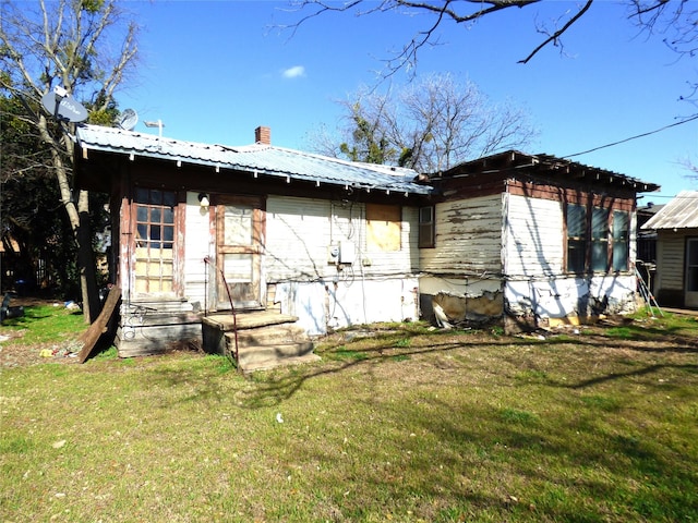 rear view of property featuring a lawn