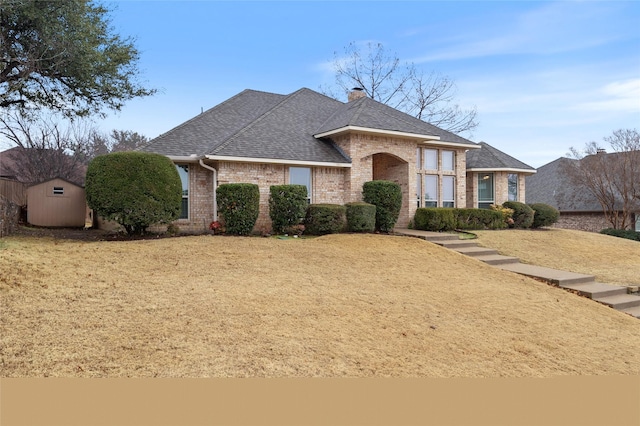 view of front of property featuring a front yard and a storage unit