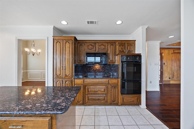 kitchen featuring crown molding, backsplash, dark stone counters, and black appliances