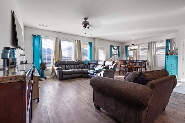 living room featuring dark hardwood / wood-style flooring and ceiling fan with notable chandelier