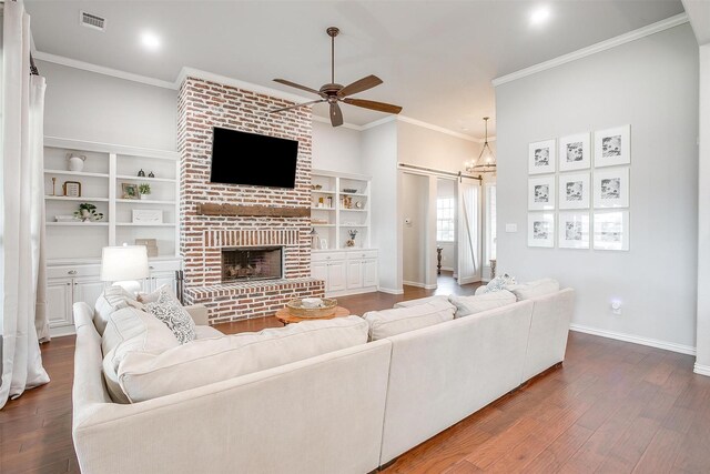 living room featuring ceiling fan with notable chandelier, ornamental molding, and dark hardwood / wood-style floors