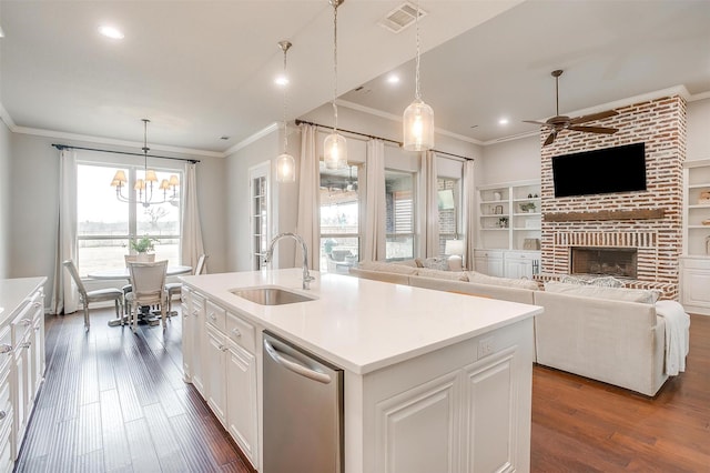 kitchen with dishwasher, sink, white cabinets, hanging light fixtures, and a kitchen island with sink