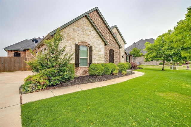 957 Prairie Timber Rd, Burleson, TX 76028 - view of side of home with fence, stone siding, brick siding, concrete driveway, and a yard