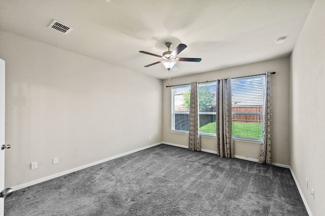 empty room with ceiling fan and dark carpet