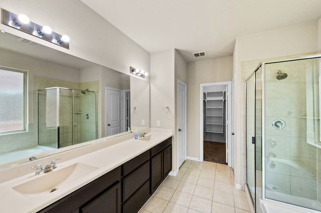 bathroom featuring tile patterned flooring, vanity, and walk in shower