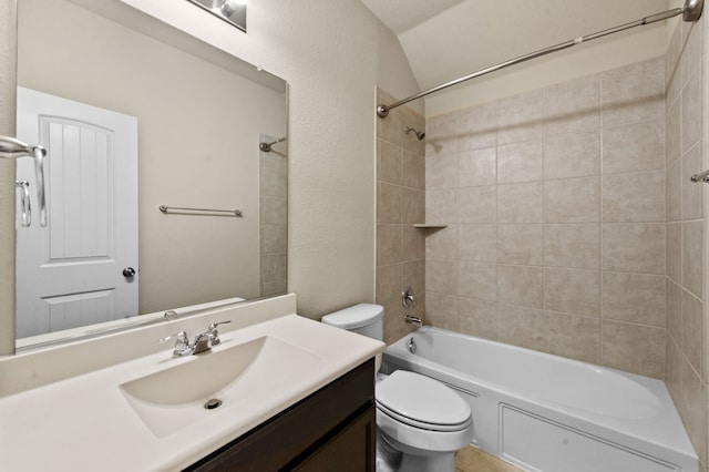 full bathroom with tiled shower / bath, vanity, and toilet