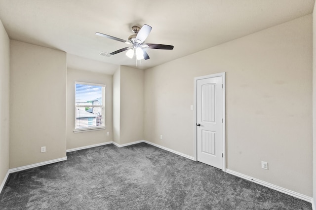 spare room featuring ceiling fan and dark colored carpet